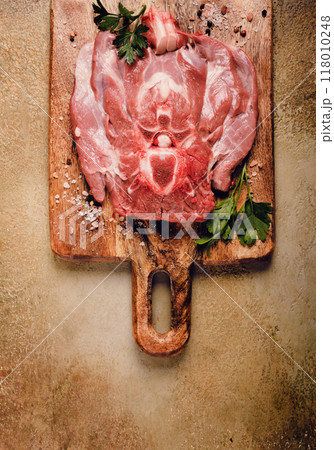 raw steak, veal neck on the bone, fresh meat, on a cutting board, with spices, top view, without people, raw steak, veal neck on the bone, fresh meat, on a cutting board, with spices, top view, without people, 118010248
