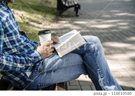 Reading a book. A young man reads a book or a textbook. Education, leisure, business concept. Reading a book. A young man reads a book or a textbook. Education, leisure, business concept. 118010580