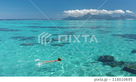 Snorkeling in clear blue waters, surrounded by tropical beauty, under a sunny sky. A dreamlike scene capturing the essence of a perfect summer vacation 118010695