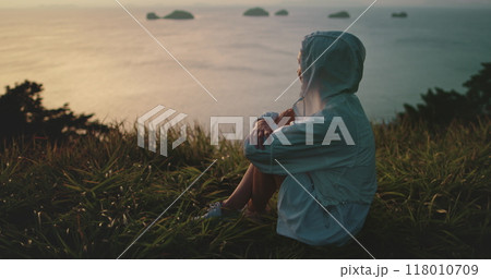 Woman enjoying a serene sunset on a tropical island, feeling calm and relaxed Woman enjoying a serene sunset on a tropical island, feeling calm and relaxed 118010709
