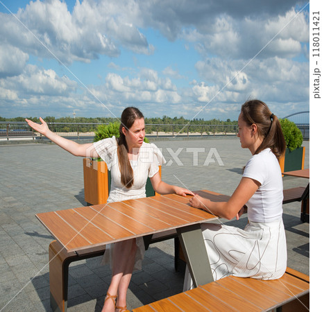 Girls arguing in a cafe Girls arguing in a cafe 118011421