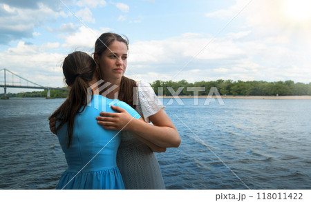 Insincere smile of a hugging girl 118011422