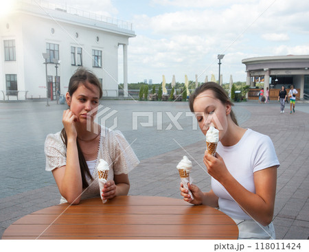 A woman looks at her friend with disapproval 118011424