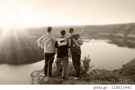 Three friends look at the valley 118011442
