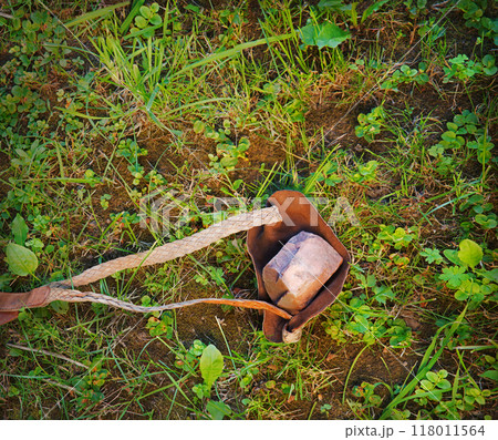An antique leather sling lies on the ground An antique leather sling lies on the ground 118011564