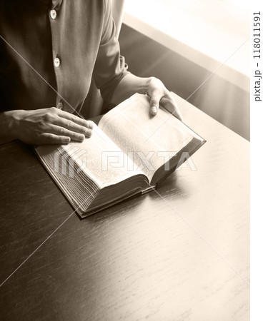 Woman's hands holding a bible 118011591