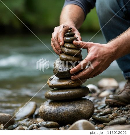 河原で石を積み上げる手のクローズアップ 118012091