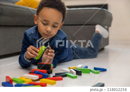 Happy cute African American boy playing with multicolored constructor Happy cute African American boy playing with multicolored constructor 118012258