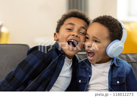 Little school boys wearing headphones listening to music singing favorite song 118012273