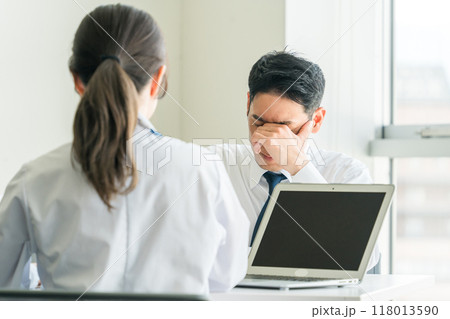 女医に診断結果を聞く男性ビジネスマン（癌・告知・深刻） 118013590