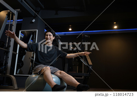バランスボールでトレーニングをする若い男性 バランスボールでトレーニングをする若い男性 118014723