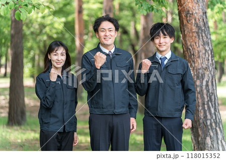 森林の中でガッツポーズする林業・土木業の作業着姿の男女の作業員 118015352