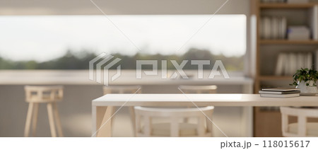 A wooden tabletop with a blurred background of a minimalist coffee shop seating area. A wooden tabletop with a blurred background of a minimalist coffee shop seating area. 118015617
