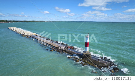 Aerial Fly Over Lighthouse Pier and Rugged Coastline 118017133