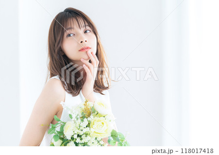 窓際でブーケを持つ若い花嫁 118017418
