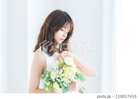 窓際でブーケを持つ若い花嫁 窓際でブーケを持つ若い花嫁 118017419