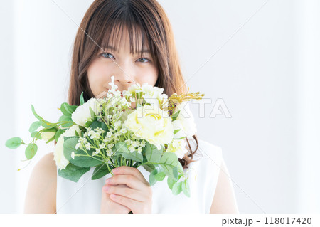 窓際でブーケを持つ若い花嫁 窓際でブーケを持つ若い花嫁 118017420