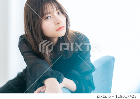 リビングの窓際でスキンケアをする若い女性 118017425