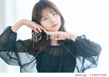 リビングの窓際でスキンケアをする若い女性 リビングの窓際でスキンケアをする若い女性 118017430