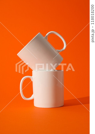White beautiful cups on an orange background 118018200
