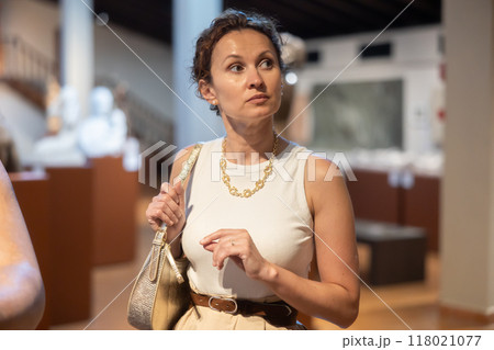 Woman visit museum, examines masterpiece at exhibition Woman visit museum, examines masterpiece at exhibition 118021077