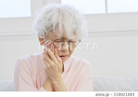 歯が痛いシニア女性　リビングルーム 118021883