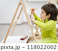 Little boy draws in studio. Art therapy, art education for children. Painting on paper on easel. Developing fine motor skills and imagination. 118022002