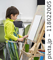 Little boy draws in studio. Art therapy, art education for children. Painting on paper on easel. Developing fine motor skills. Mock up. 118022005