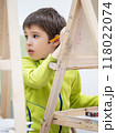 Little boy draws in studio. Art therapy, art education for children. Painting on paper on easel. Developing fine motor skills and imagination. 118022074