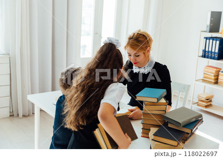Woman teacher and children schoolchildren in the library with books Woman teacher and children schoolchildren in the library with books 118022697