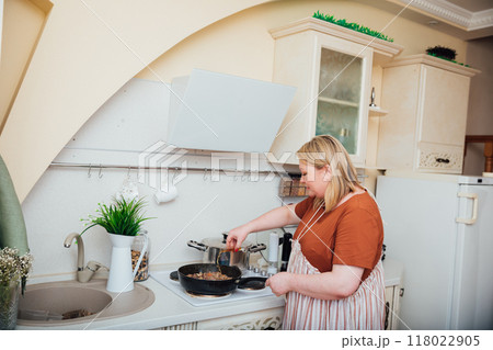 Woman Cook Housewife Cooks Delicious Dinner For Family Woman Cook Housewife Cooks Delicious Dinner For Family 118022905