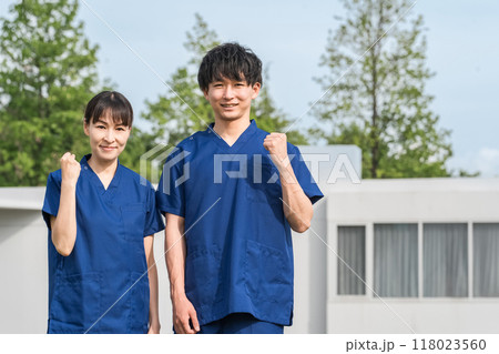 病院・施設の前にいるスクラブをきた医療従事者の男女スタッフ（看護師・介護士・介護福祉士） 118023560