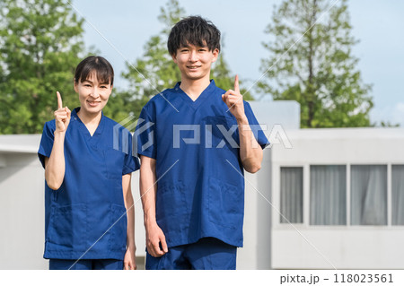 病院・施設の前にいるスクラブをきた医療従事者の男女スタッフ（作業療法士・看護師） 118023561
