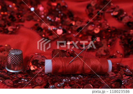 Red Beaded Fabric With Spool of Thread and Thimble Red Beaded Fabric With Spool of Thread and Thimble 118023586