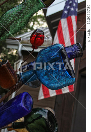 Vintage Recycled Bottles on Metal Rack With American Flag in Background Vintage Recycled Bottles on Metal Rack With American Flag in Background 118023789