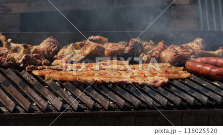 Assorted Meats Grilling Over a Smoky Barbecue Assorted Meats Grilling Over a Smoky Barbecue 118025520