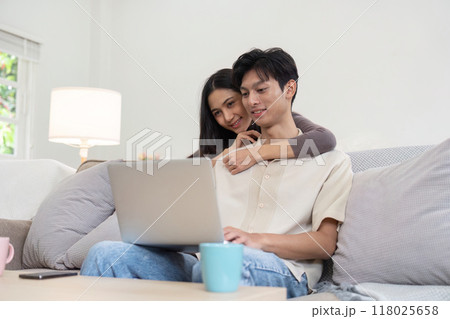 Couple sharing a peaceful moment while looking at a laptop 118025658