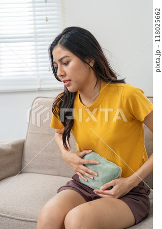 Managing menstrual cramps with a hot water bottle at home Managing menstrual cramps with a hot water bottle at home 118025662