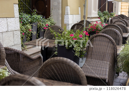 Furniture on the terrace in a cafe on the square with a beautiful interior and blooming flowers in the city, morning time 118026478