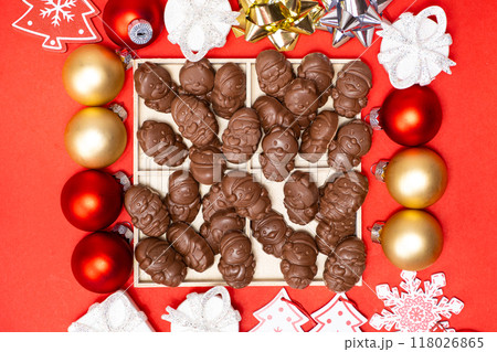 Chocolates in the shape of Christmas figures on the red background top view 118026865