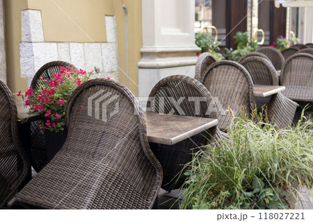 Furniture on the terrace in a cafe on the square with a beautiful interior and blooming flowers in the city, morning time 118027221