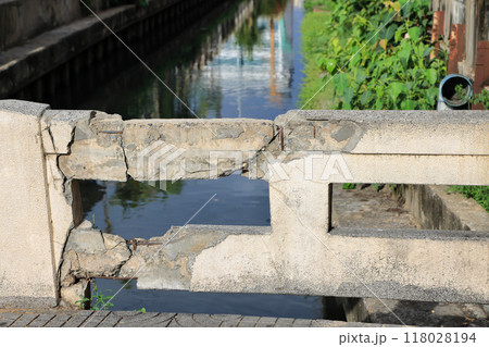 Cracked grey concrete surface with visible reinforcement, Rust in reinforcement of Concrete bridge, Broken or weak concrete. 118028194