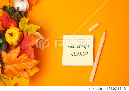Note autumn trends and yellow leaves on orange background. Popular and relevant topics. New ideological trends of fashion. Recent and latest trend. Note autumn trends and yellow leaves on orange background. Popular and relevant topics. New ideological trends of fashion. Recent and latest trend. 118029348