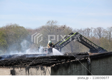 Firefighter putting out a fire in a house Firefighter putting out a fire in a house 118030077