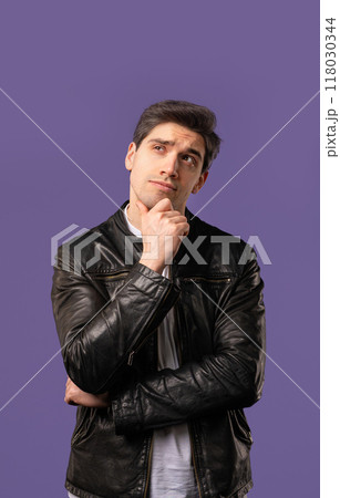Portrait of curious analyzing man in violet studio. Mindful guy finding solution Portrait of curious analyzing man in violet studio. Mindful guy finding solution 118030344