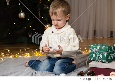 Little two-year-old boy opens Christmas gifts at home 118030710