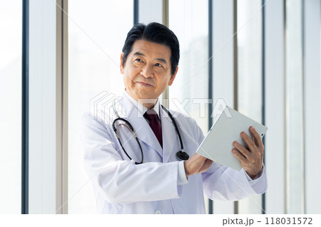 タブレットを操作するシニアの医師　撮影協力：学校法人電波学園　東京電子専門学校 118031572