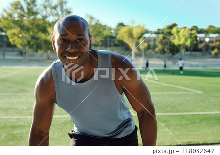 Atheltic man posing for camera, soccer field on background 118032647