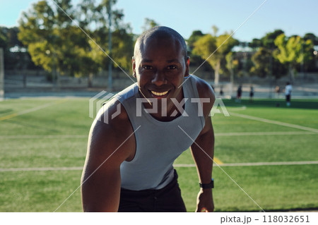 Atheltic man posing for camera, soccer field on background 118032651