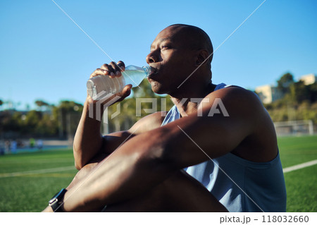 Athletic man drinks still or mineral water outdoors 118032660